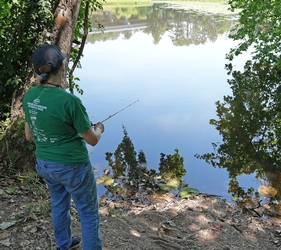 adult fishing in a pond