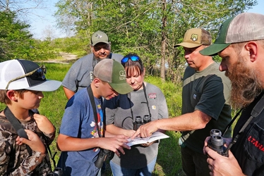 group gathered recording bird identification details