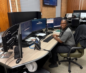 LDWF Employee posing in front of her enforcement communications desk