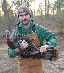 LDWF Private Lands Biologist man holding a female turkey