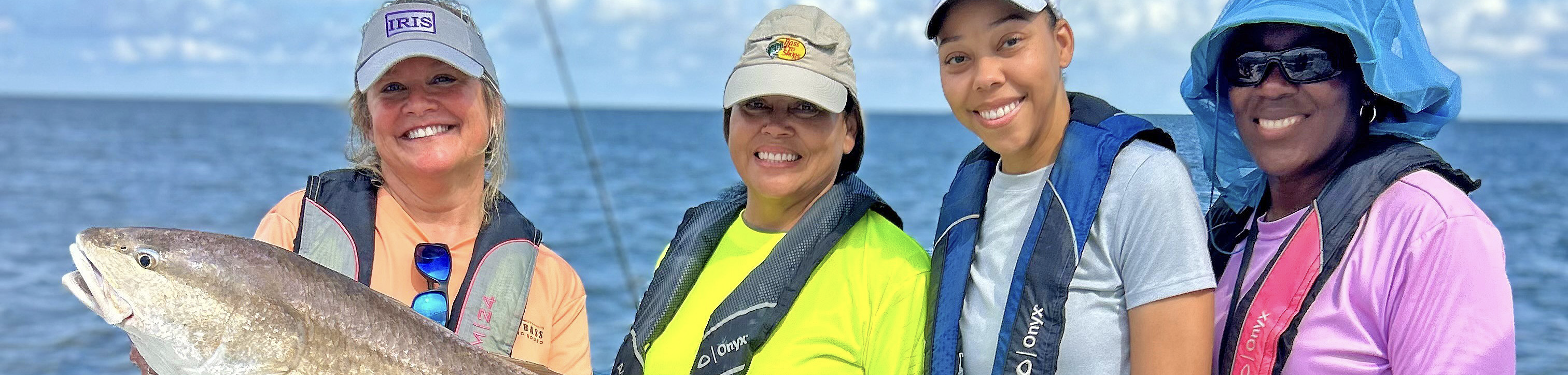 Women holding a red fish on a boat
