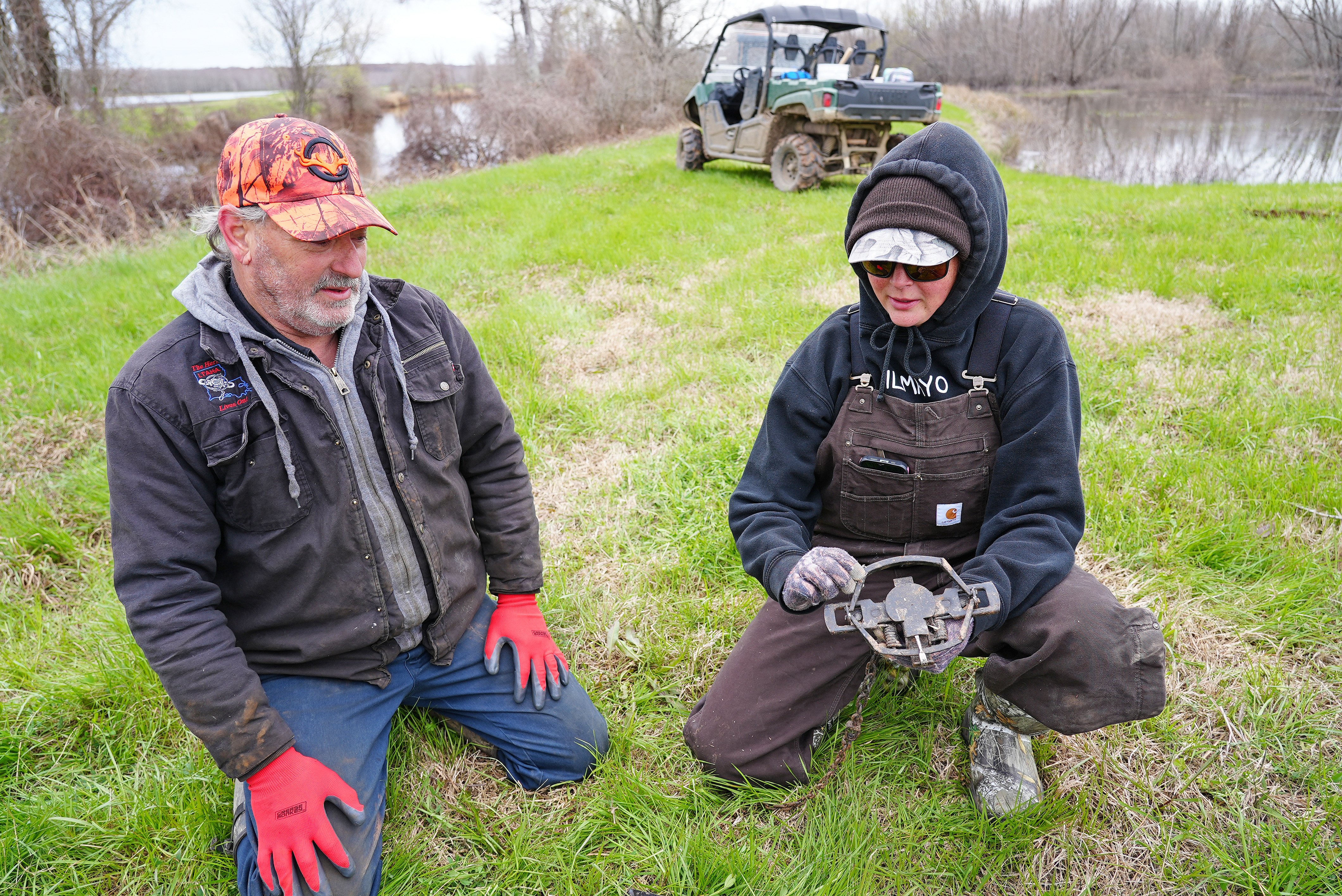 Professional trapper Leon Petty (left) with the Louisiana Trappers and Alligator Hunters Association provides guidance as a student sets the jaws of a foothold trap used to catch larger animals, such as coyotes, during a 3-day trapper workshop