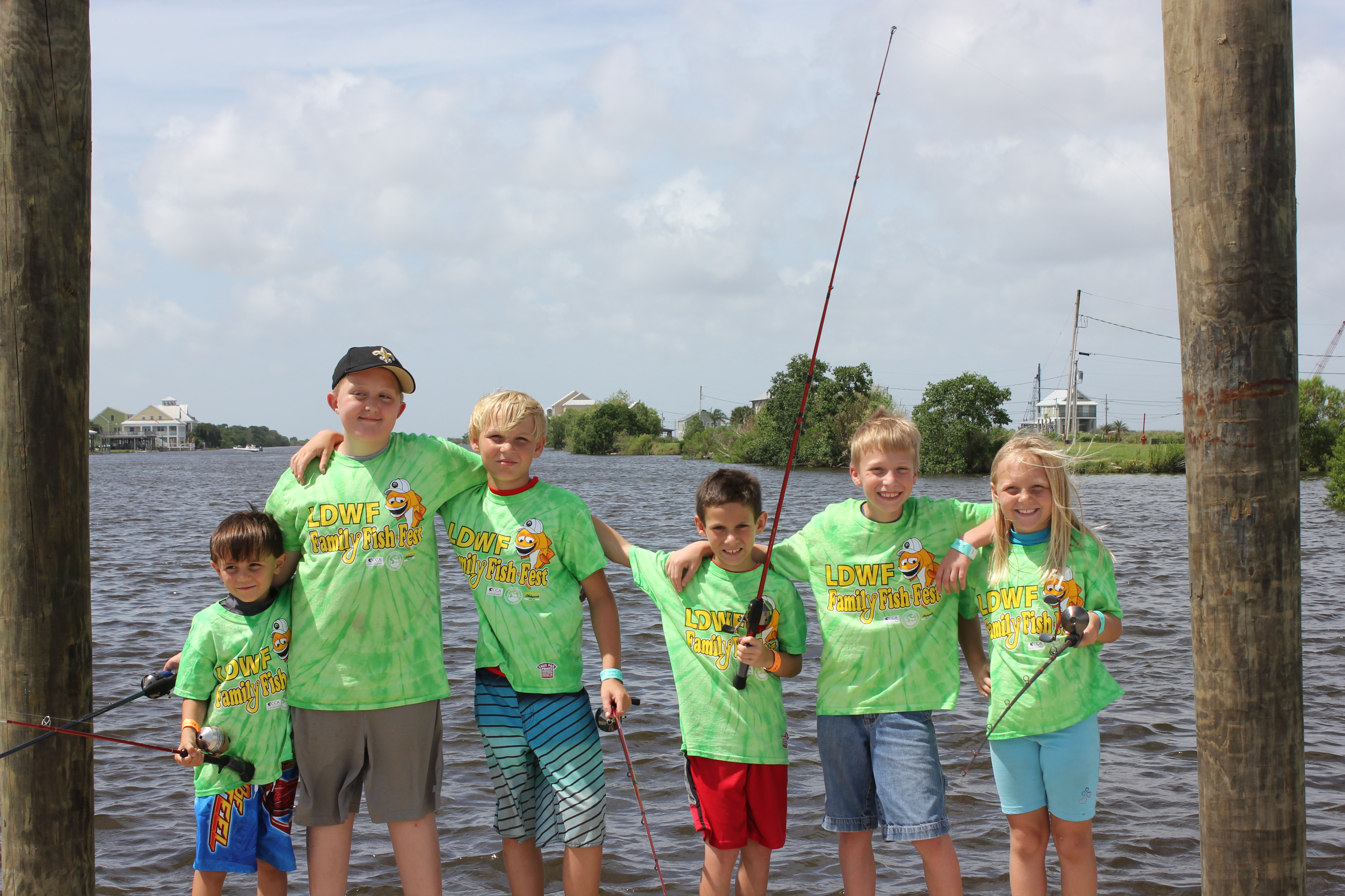 Participants from a Family Fish Fest take a quick break from fishing to pose for a picture.