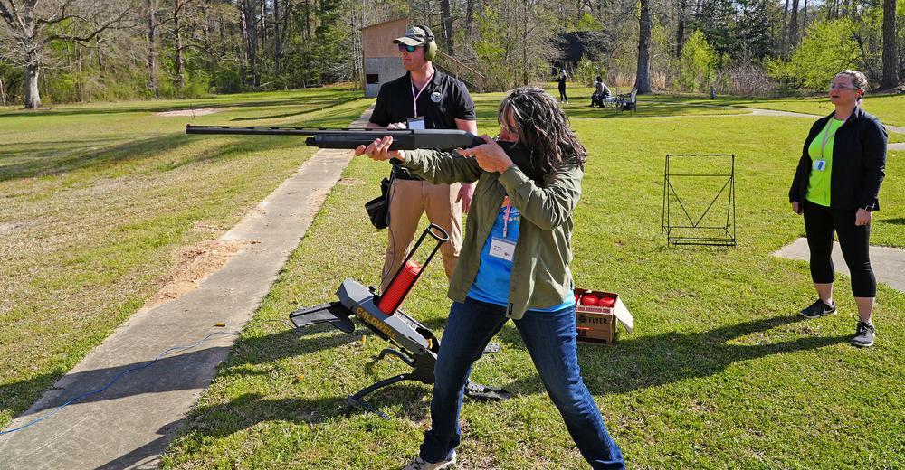 Woman shooting a shotgun