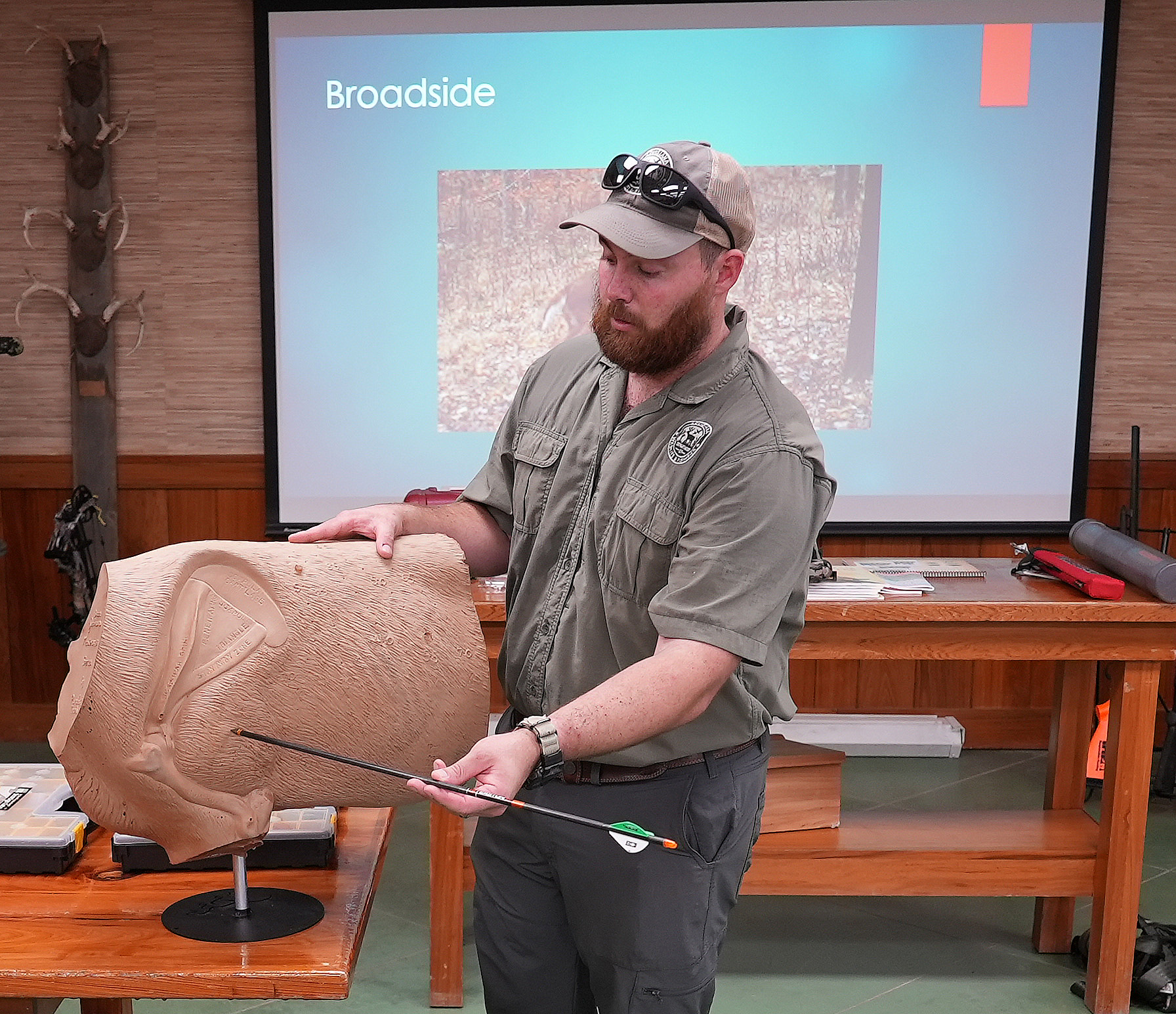 Bow Hunting instructor showing with an arrow where to shoot an animal