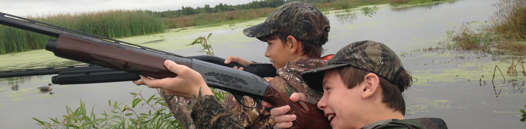 Boys duck hunting in the marsh
