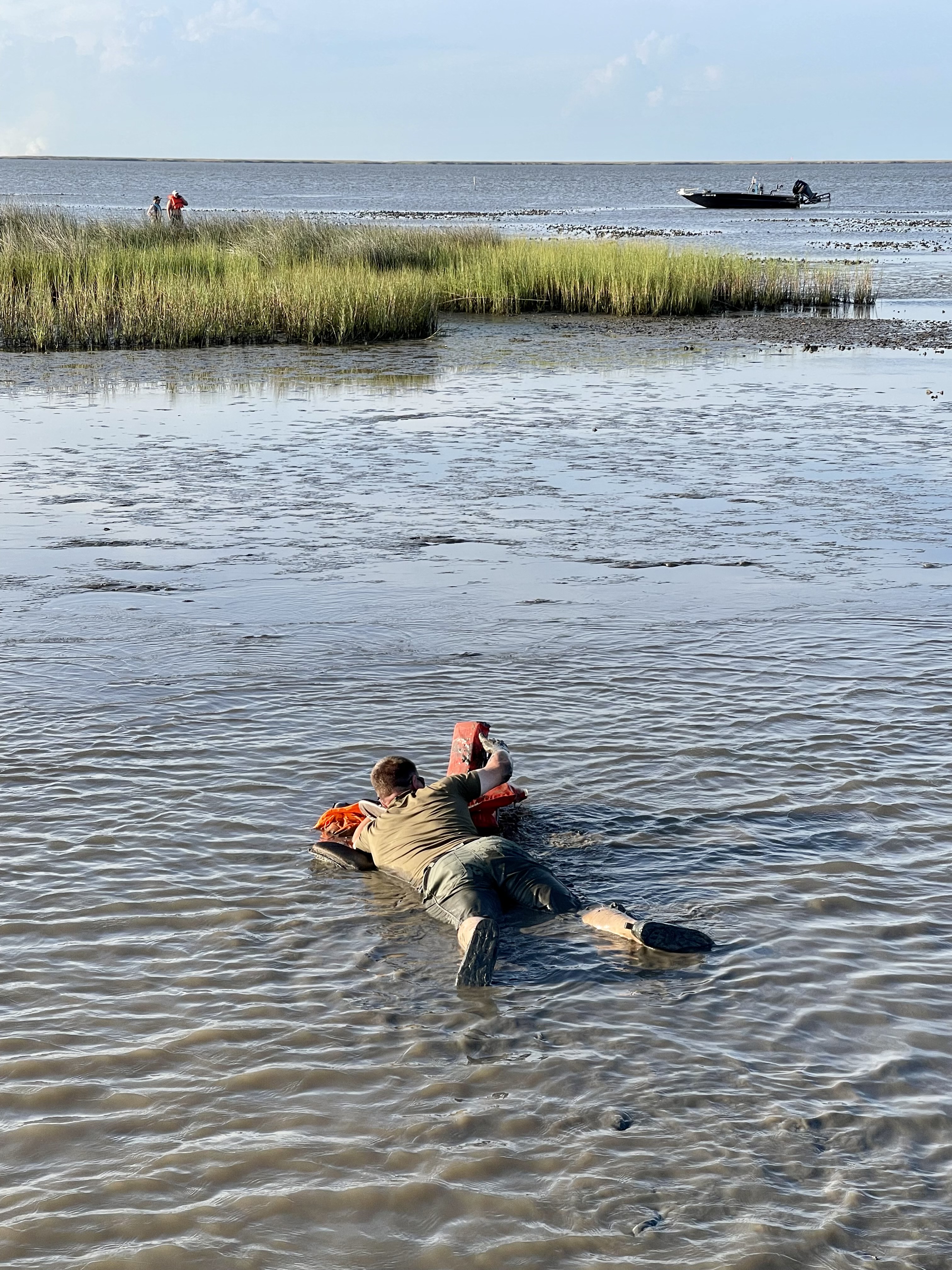 Senior Agent Joshua Segrest makes his way through the mud to get to the stranded boaters.