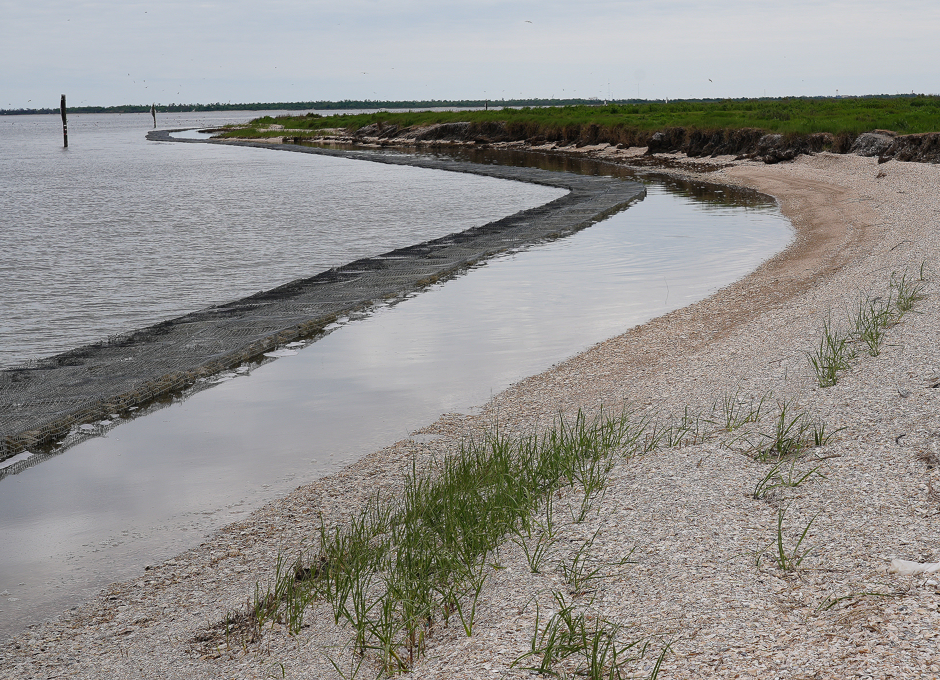 A shoreline protection system protects Rabbit Island from wave erosion. The rock-filled baskets attenuate the waves, leaving smooth, calm water along the island shore. [ Credit: Jim Smilie ]